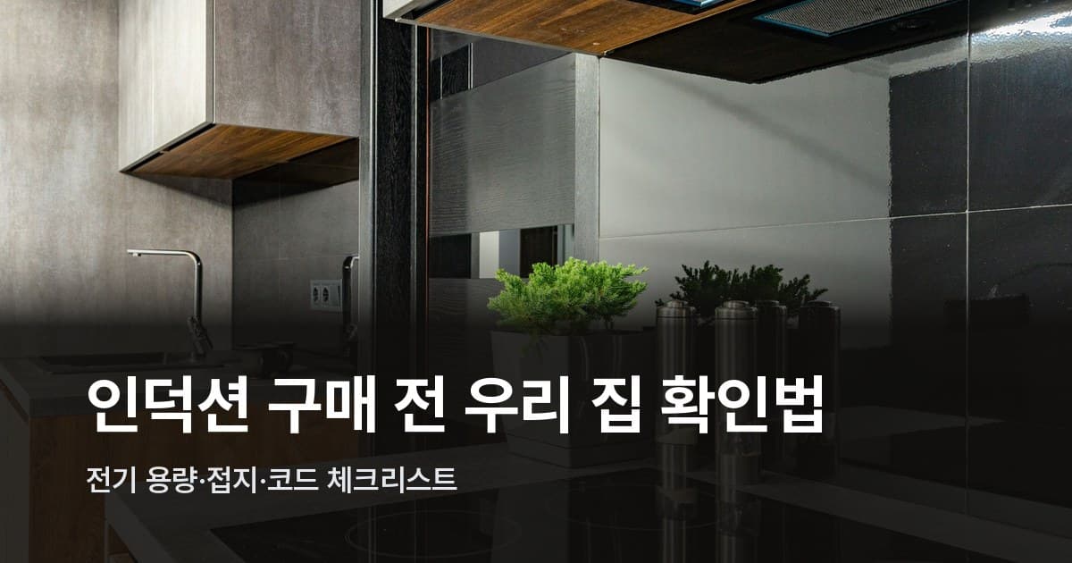 검은 세라믹 인덕션 쿡탑이 전면에 있는 어두운 톤의 현대식 주방